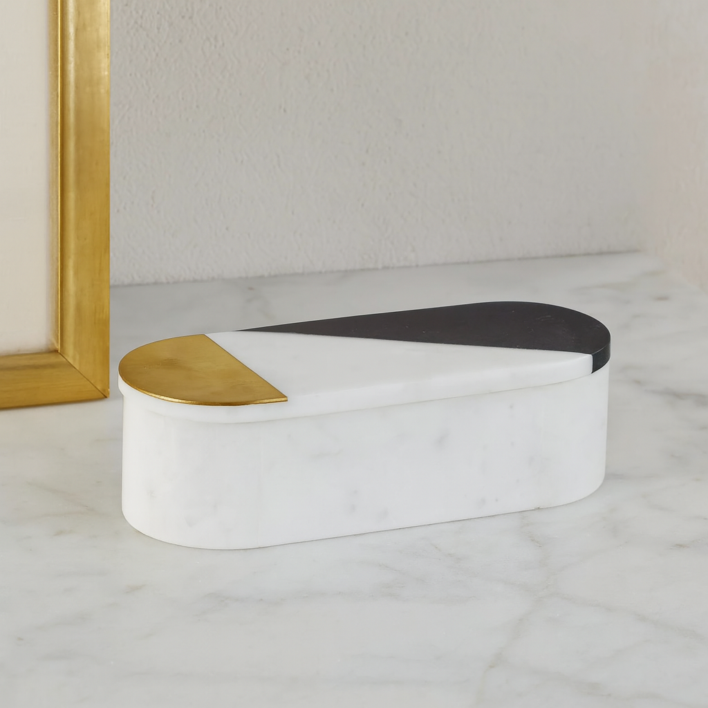 Luxury white marble decorative box with two-tone gold and black lid styled on marble surface in modern home décor