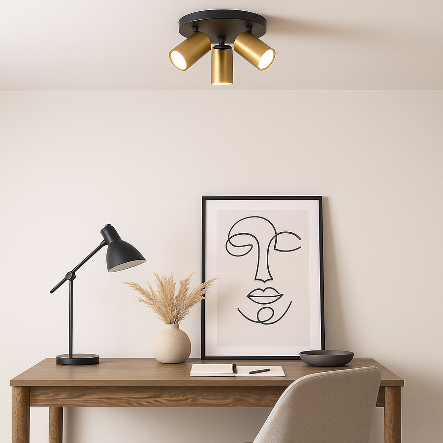 Modern home office with wooden desk, minimalist artwork, and a black and gold three-light flush ceiling fitting providing warm illumination