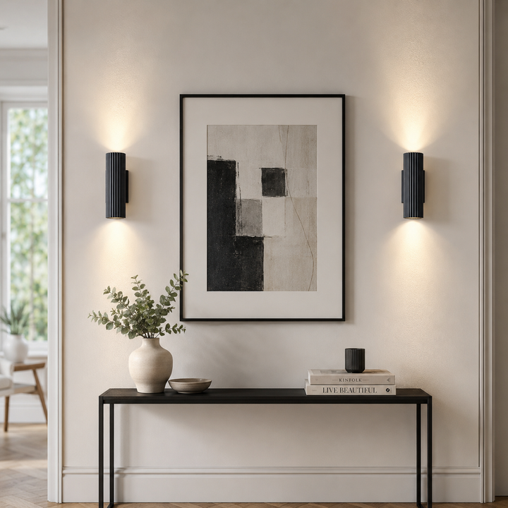 Black ribbed wall lights beside framed wall art.
