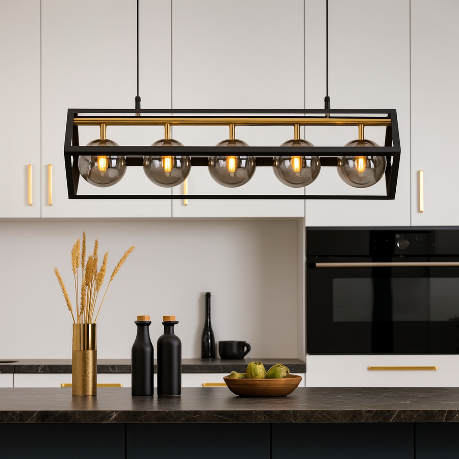 Rectangular black and gold pendant light with smoked glass globes hanging above a modern kitchen island.