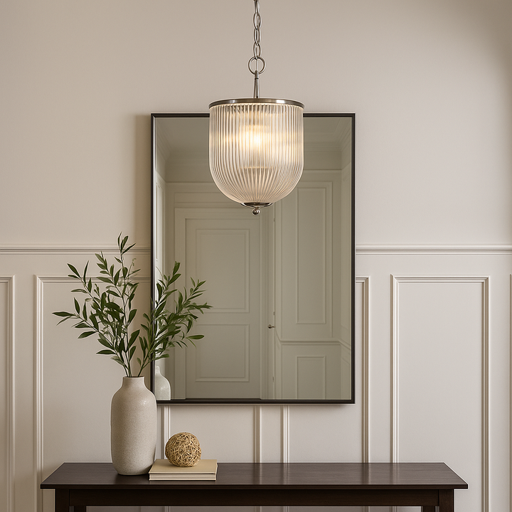 Ribbed glass pendant light with chrome trim hanging higher above a console table and mirror in a modern Georgian hallway with wall panelling.