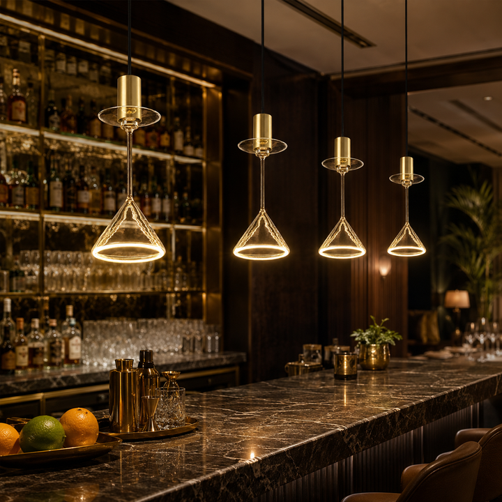 Roma cocktail glass aura ring pendant lights with gold caps hanging above a luxury cocktail bar with warm ambient lighting.