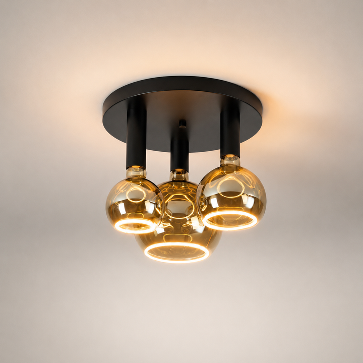 Roma small 3 light flush ceiling light with all black frame and smoked Roma Aura bulbs in a luxury square hero image.
