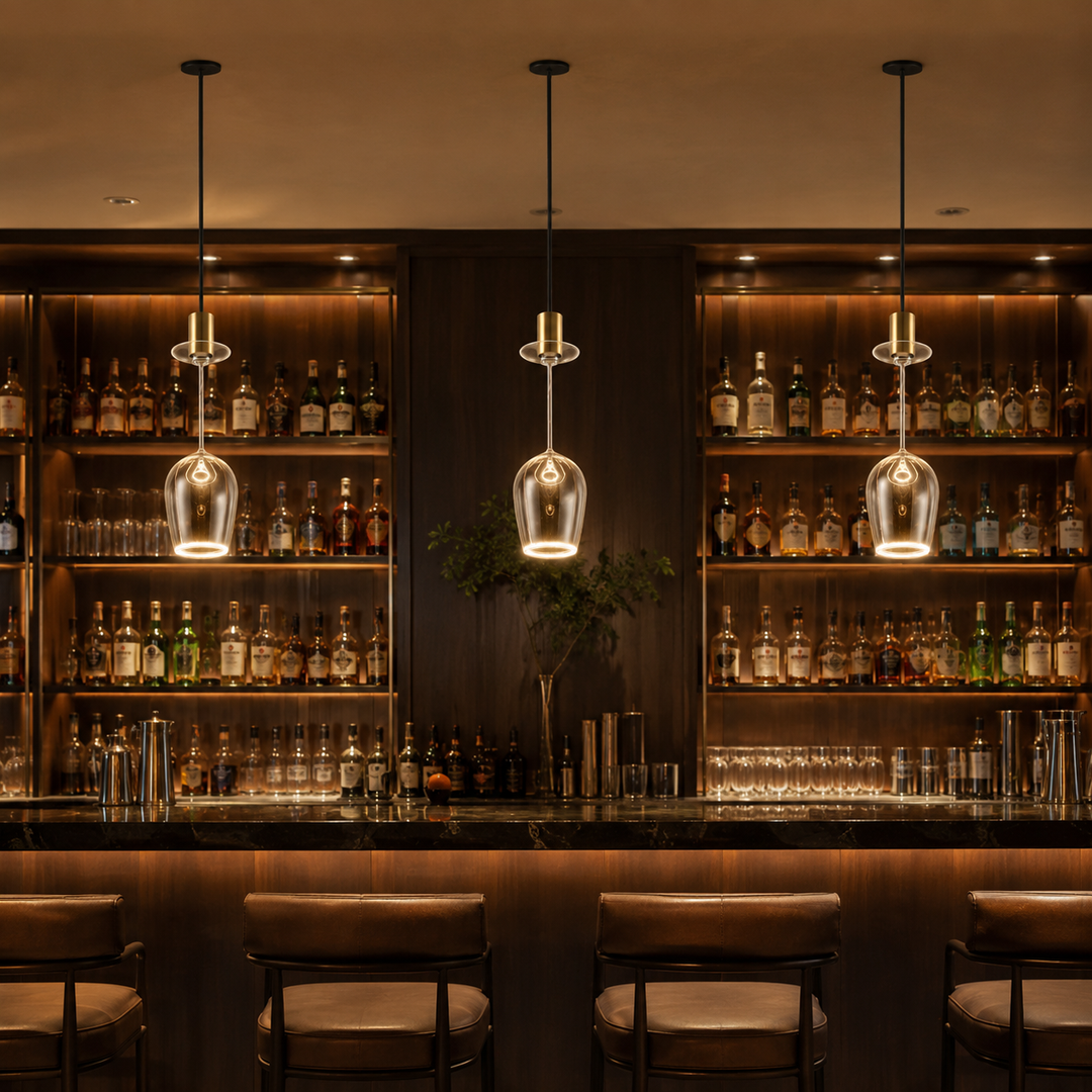 Roma wine glass Aura Ring pendant lights with black ceiling plates and gold caps hanging above a luxury bar with warm ambient lighting.