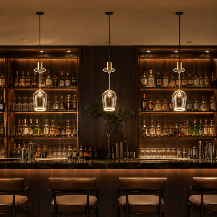 Roma wine glass Aura Ring pendant lights with black ceiling plates and gold caps hanging above a luxury bar with warm ambient lighting.