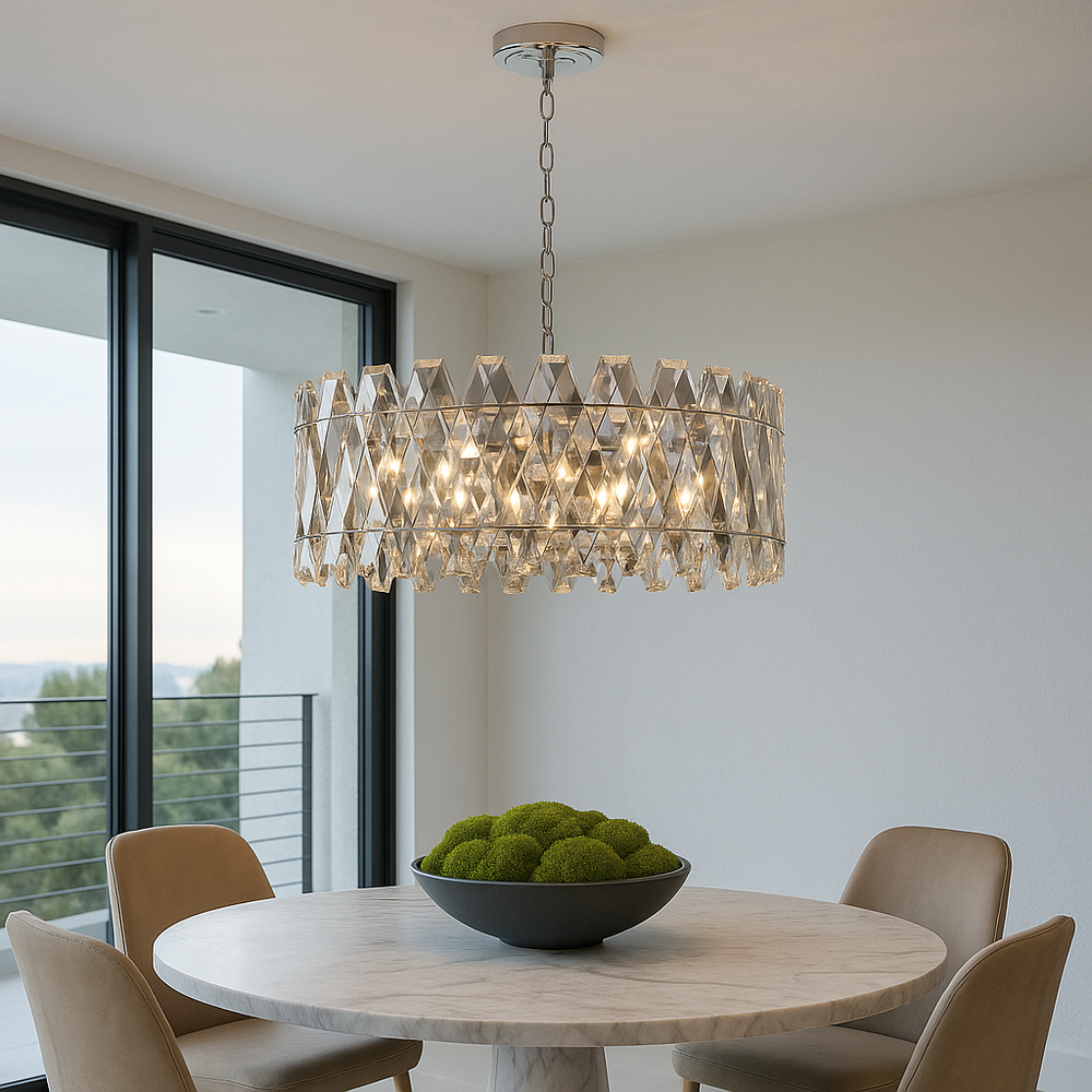 Luxury silver crystal chandelier hanging above a round marble dining table with modern chairs and a decorative bowl of green moss, styled in a bright Selling Sunset inspired interior.