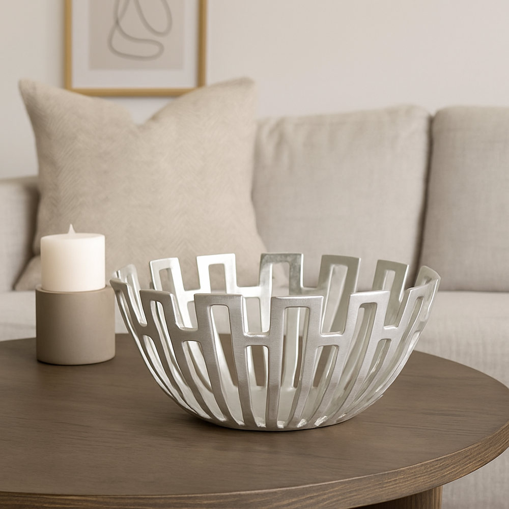 Luxury silver decorative metal bowl with geometric lattice design styled on wooden coffee table in modern neutral living room
