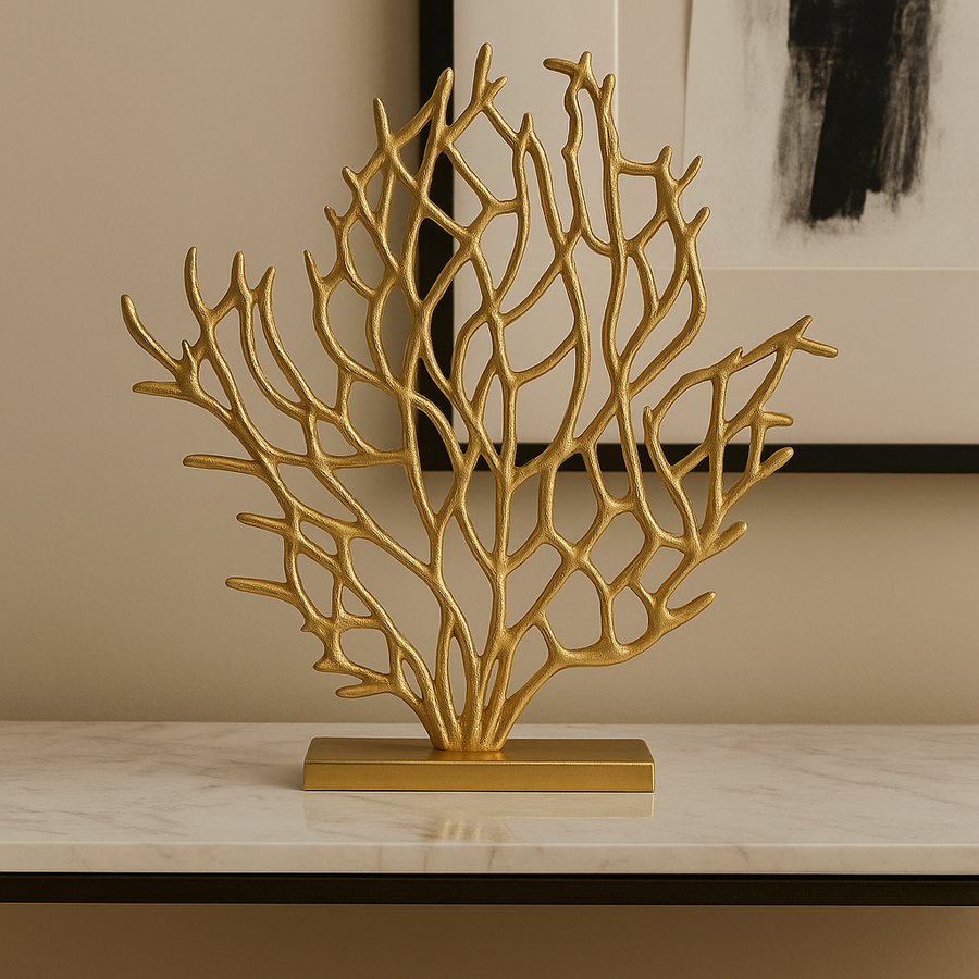 Gold coral-like decorative piece on a marble surface with a neutral background