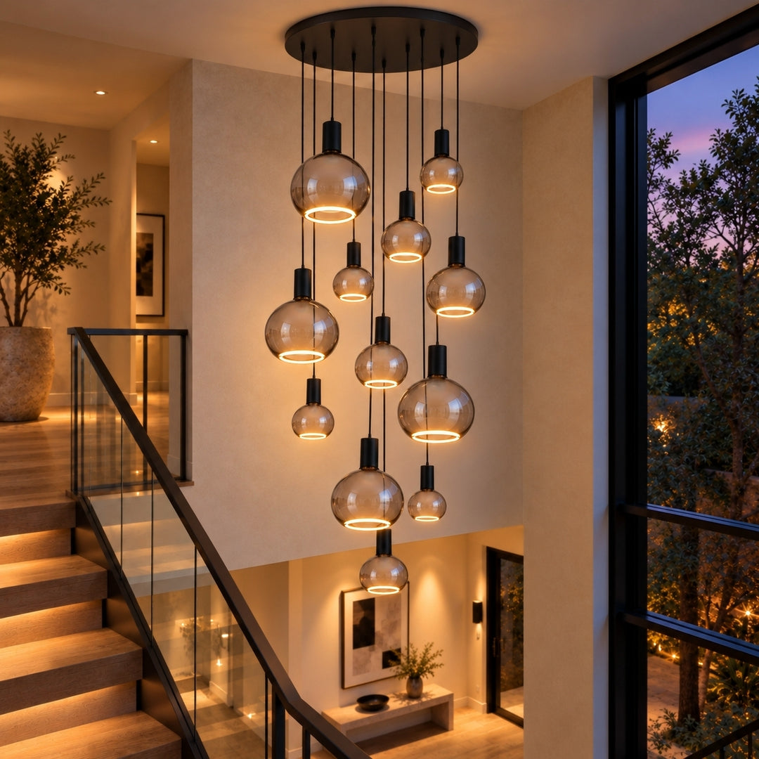 Modern smoked glass LED spiral pendant chandelier with black fittings and warm white LED rings, suspended at staggered heights over a contemporary staircase.