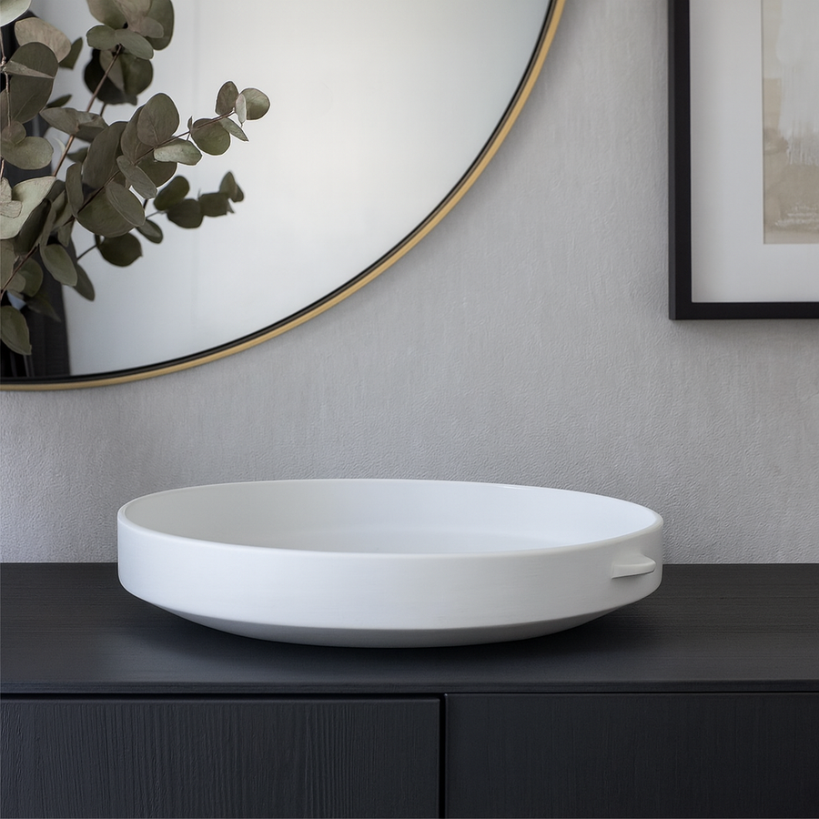 Luxury white ceramic decorative bowl styled on a black sideboard with mirror and artwork in a modern home interior