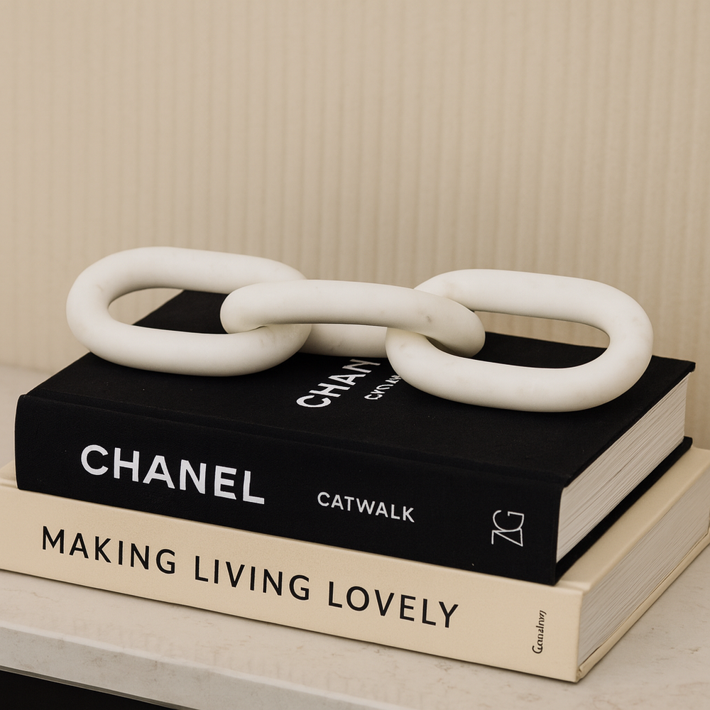 Luxury white marble chain link sculpture displayed on designer styling books, modern home décor accessory