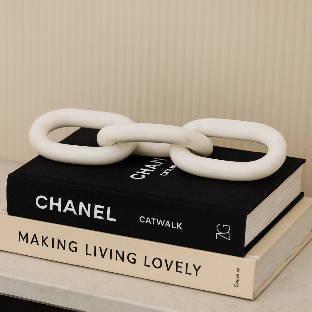 Luxury white marble chain link sculpture displayed on designer styling books, modern home décor accessory