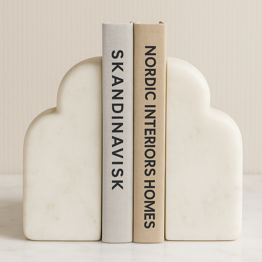Luxury white marble cloud-shaped bookends with Nordic interior design books on a marble surface