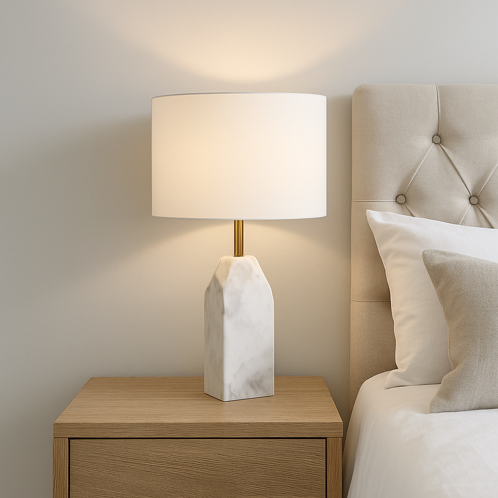 Luxury white marble table lamp with white drum shade styled on a wooden bedside table in a modern neutral bedroom