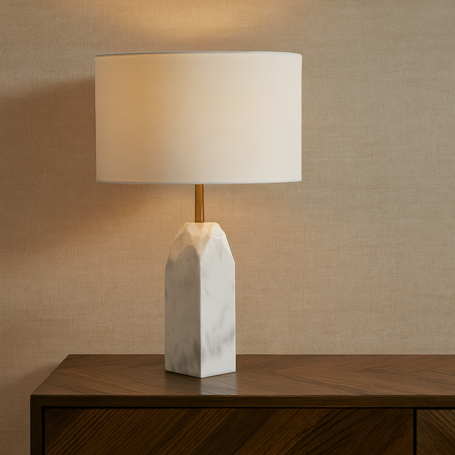 Luxury white marble table lamp with gold detail and white drum shade styled on a wooden sideboard in a modern interior