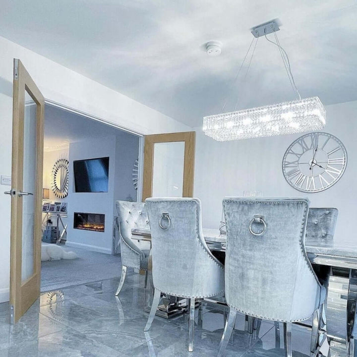 Salzburg rectangular chandelier with crystal and chrome design, styled above a luxury dining table.